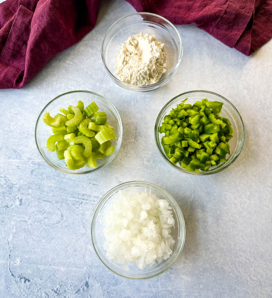 flour, chopped green peppers, chopped celery, and chopped white onions in separate glass bowls