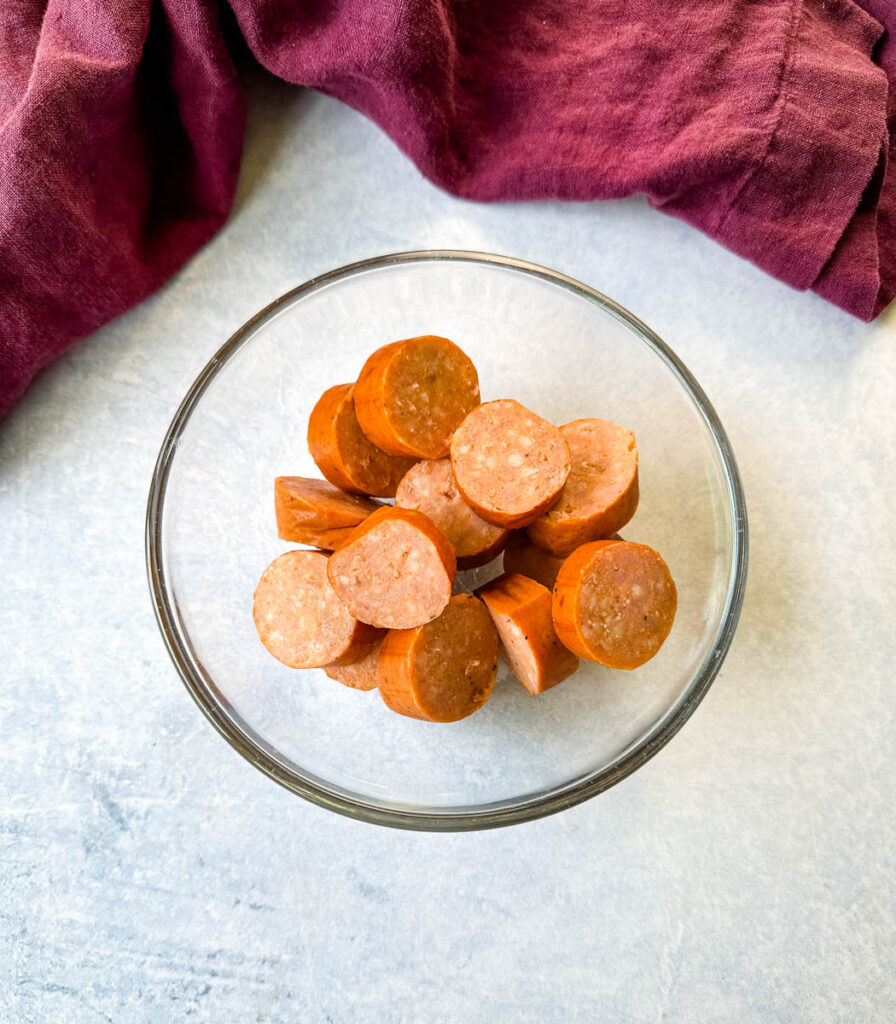 andouille sausage sliced into rounds in a glass bowl