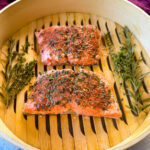 steamed salmon in a steamer basket with herbs