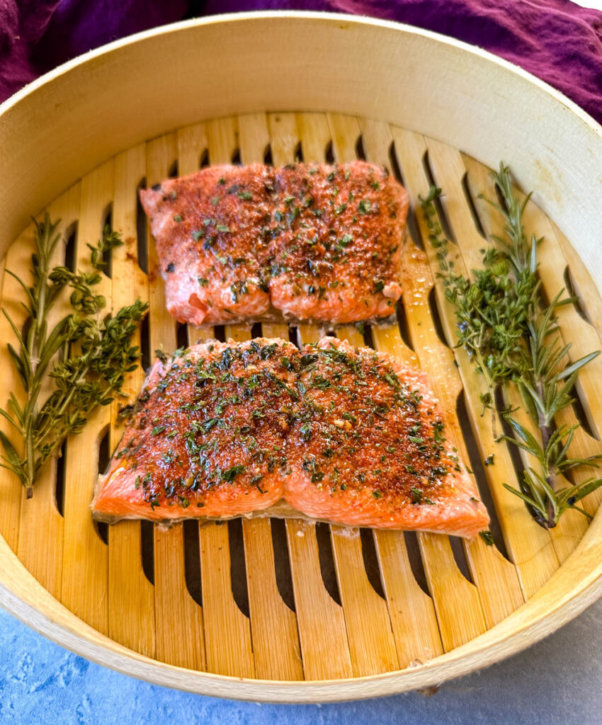 steamed salmon in a steamer basket with herbs