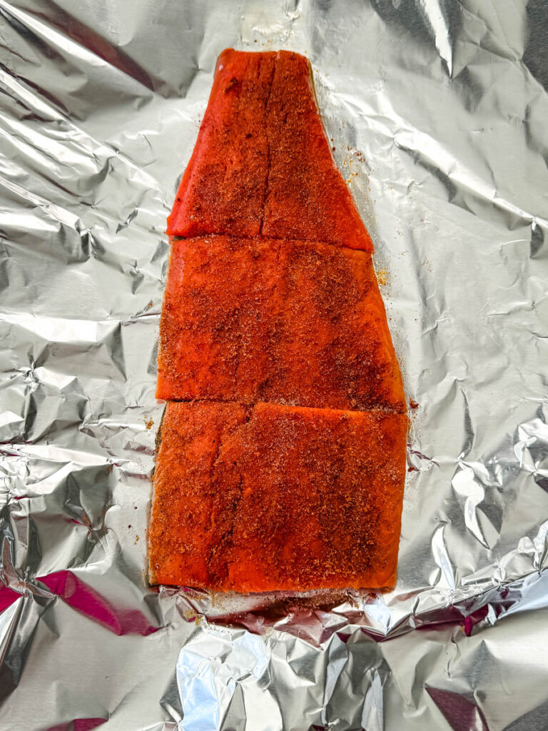 raw seasoned salmon filets on foil