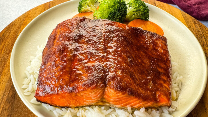salmon glazed with brown sugar, butter, soy sauce with vegetables on a white plate