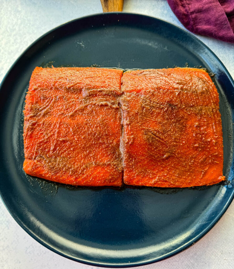 raw salmon glazed with brown sugar, butter, soy sauce, and spices on a blue plate
