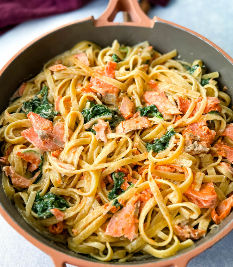salmon Fettuccine Alfredo with spinach in a pan