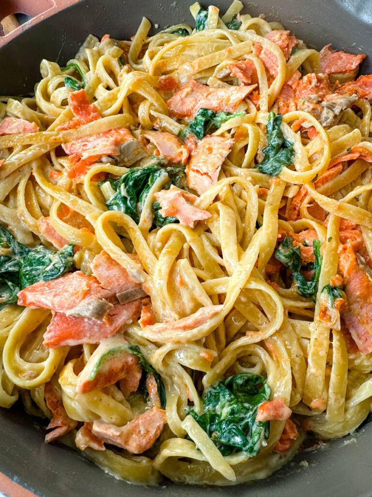salmon Fettuccine Alfredo with spinach in a pan
