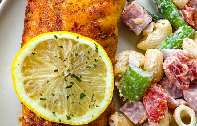 pan fried cod on a plate with pasta salad