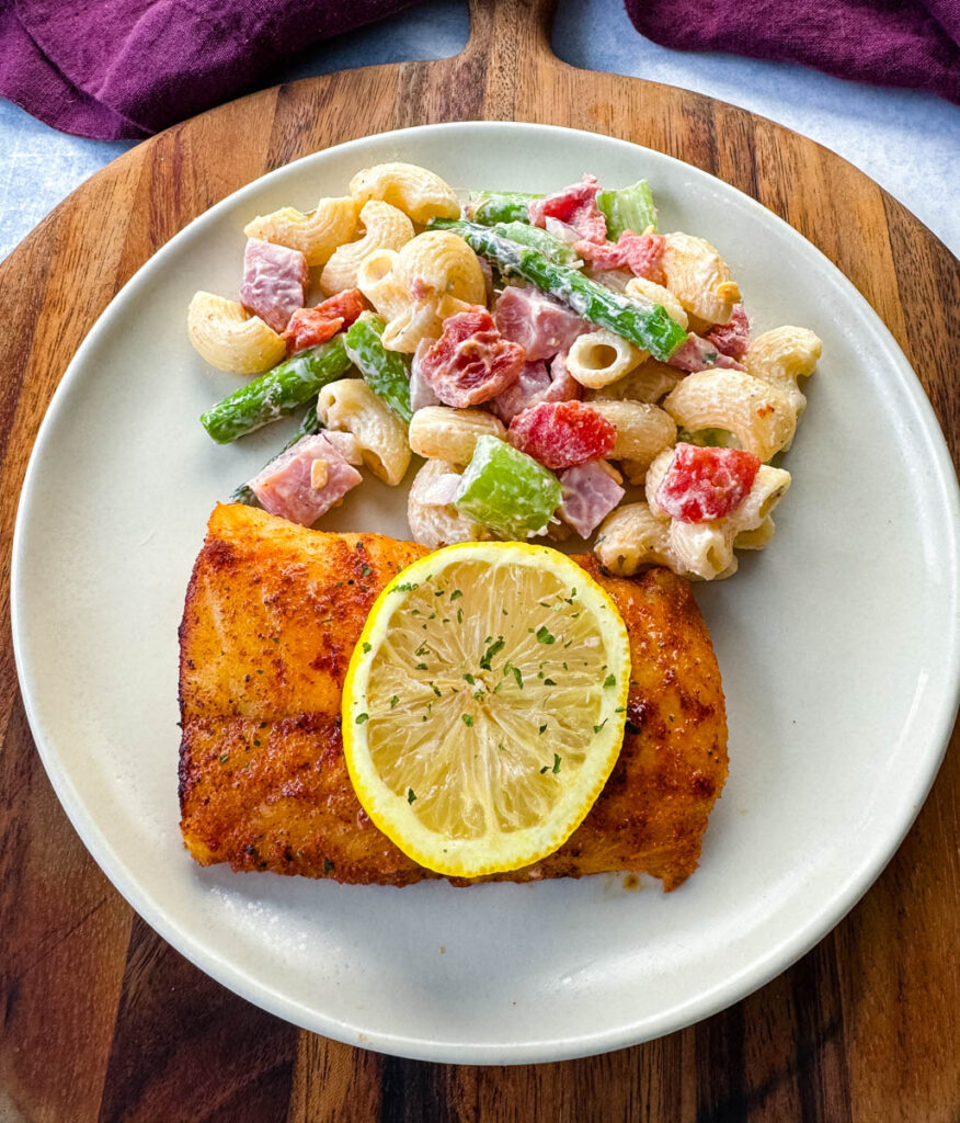 pan fried cod on a plate with pasta salad