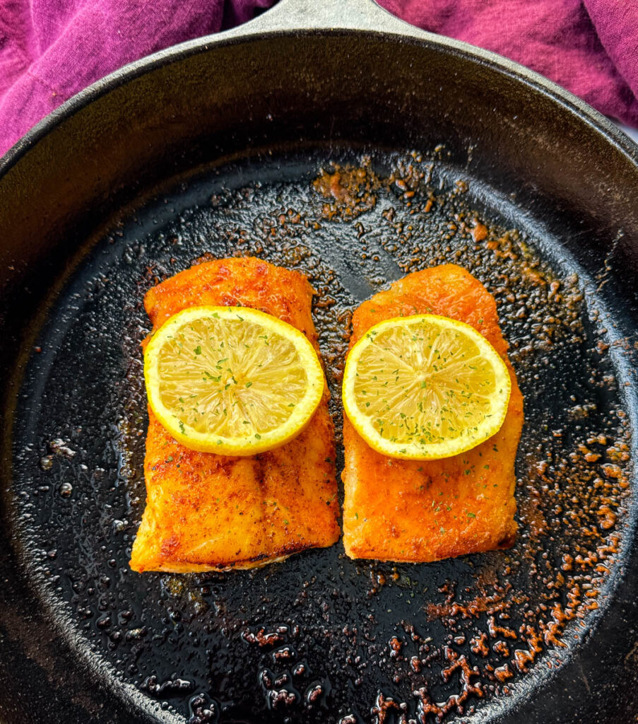 pan fried cod fish fillets with lemon in a cast iron skillet