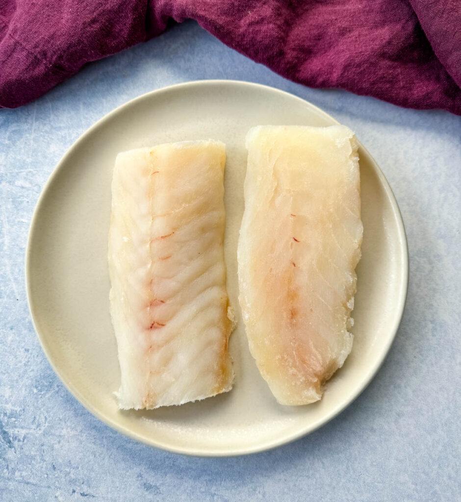 raw cod fish fillets on a plate